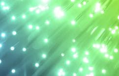 Abstract background with green and blue light streaks and glowing white dots, symbolizing energy and innovation.