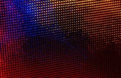 Abstract colorful pixelated background in blue, red, and orange tones.