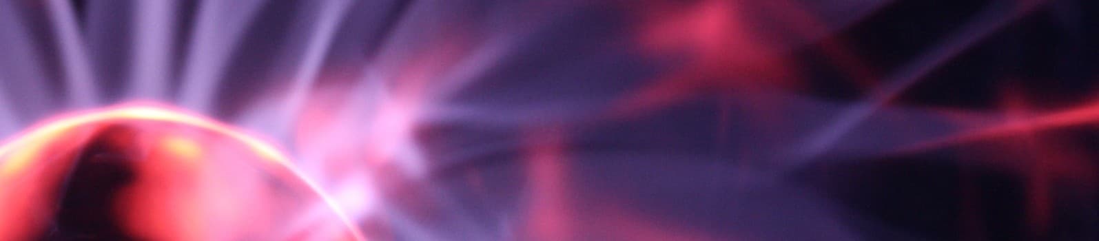 Abstract purple and pink light blurs on a dark background.